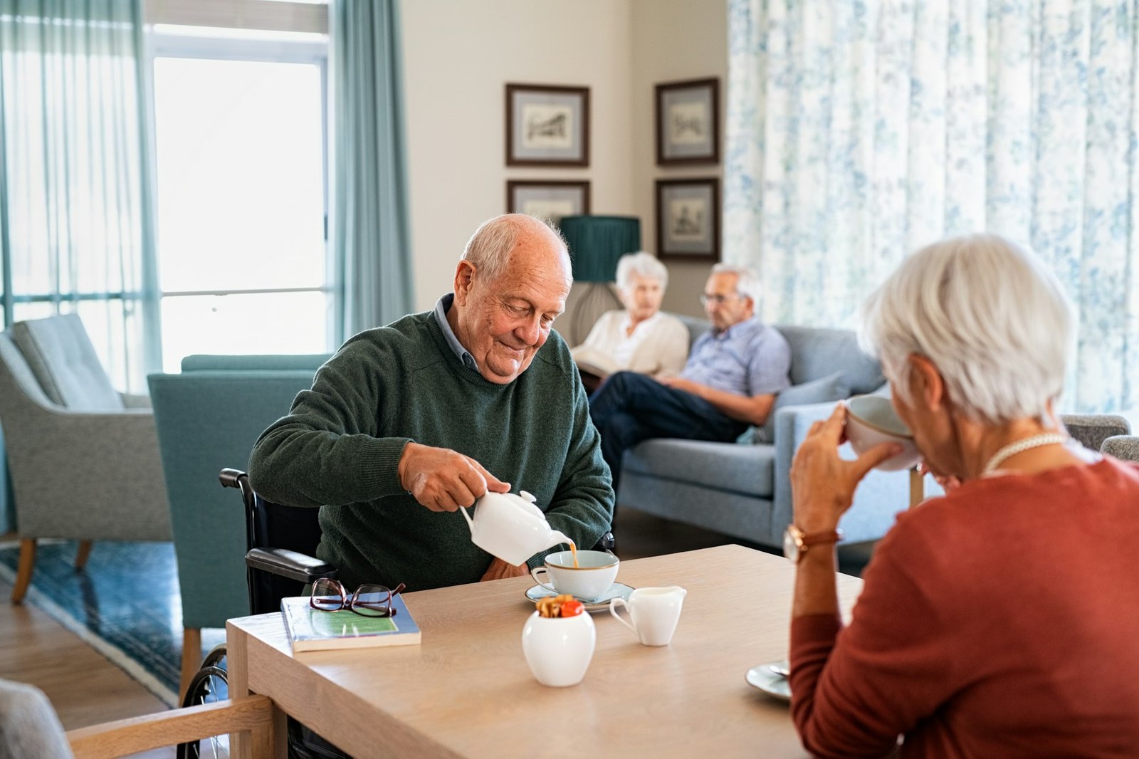 Senior man drinking hot tea with his wife at retirement community
